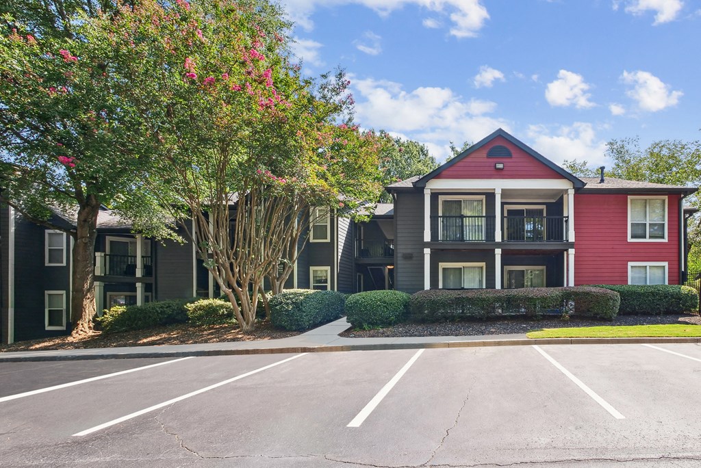 A red and grey building with a parking lot in front at Elme Druid Hills, Atlanta, Georgia
